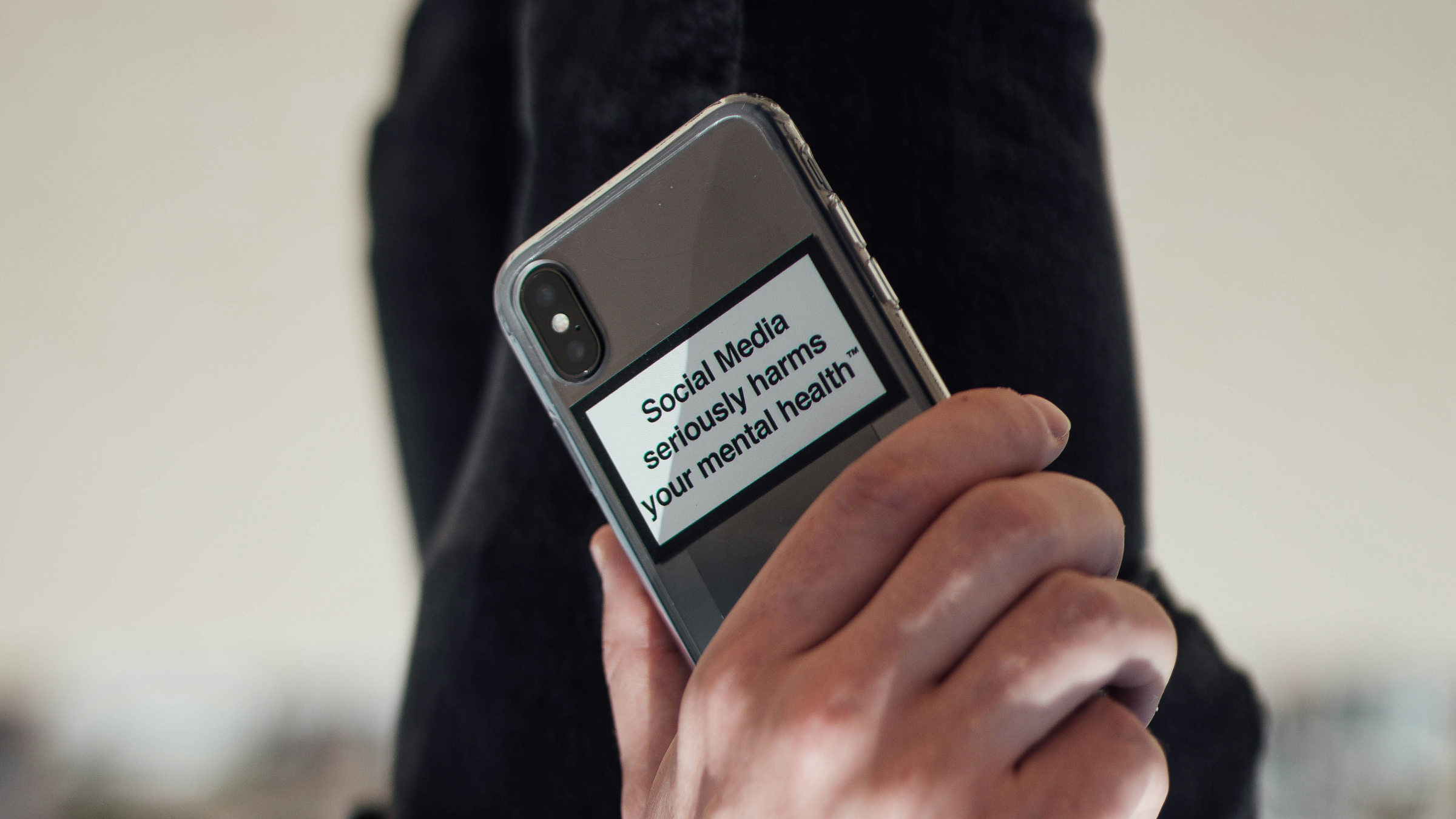 Sticker on the back of a phone that reads "social media seriously harms your mental health"